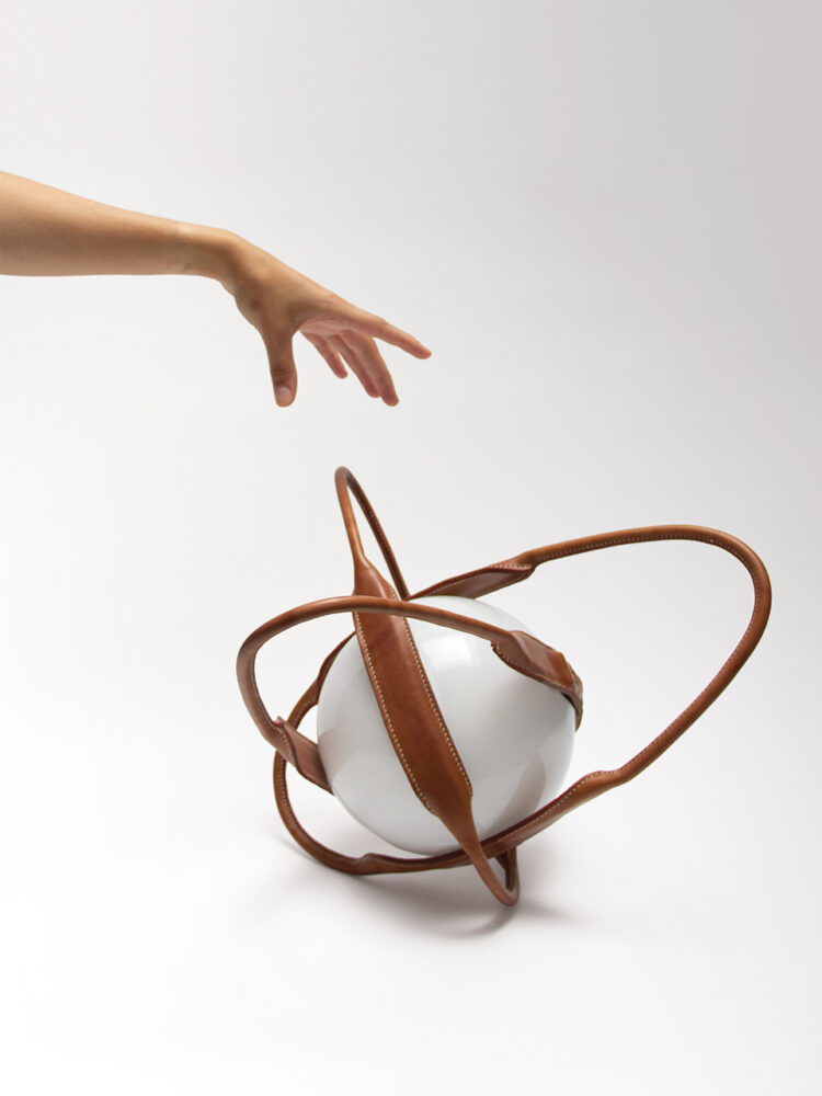 Oz de Lisa Riou renouvelle la forme de la lanterne. Telle une sphère armillaire, elle peut se poser, se suspendre, être déplacée grâce à ses anses en cuir en forme d’ellipses.