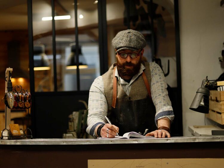 Jimmy Grandadam, fondateur de Maison Grandadam dans son atelier-boutique de maroquinerie-cordonnerie.