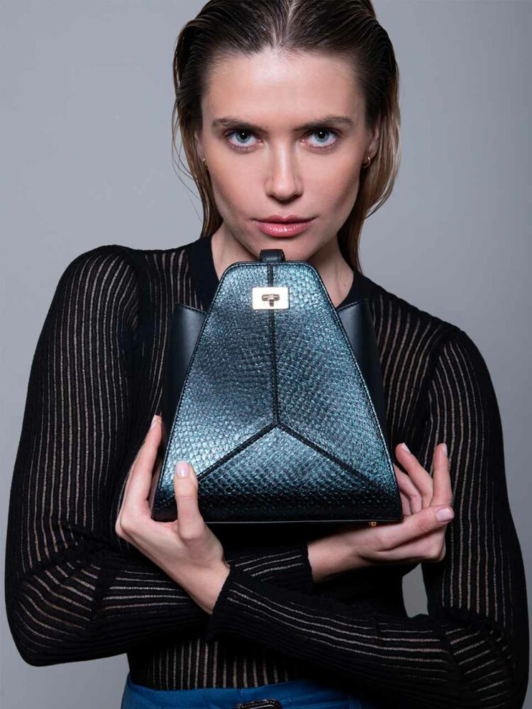 Thalie Paris est une jeune marque de maroquinerie éco-conçue. Livia est un sac bracelet triangulaire combinant cuir de veau et cuir de saumon recyclé et tanné par Ictyos. 695€ prix boutique conseillé.