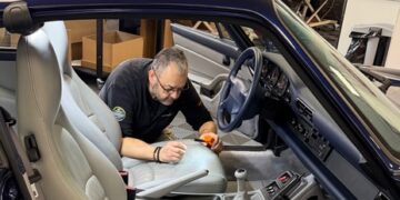 Christophe Magy, dirigeant de l’atelier Renov’Cuir, en plein travail de réparation d’un cuir de siège.